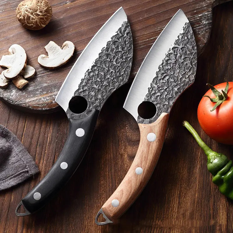 Deux couteaux de cuisinier d’extérieur forgés en acier à haute teneur en carbone, avec des lames martelées, l’un avec un manche noir et l’autre avec un manche en bois clair fixé par des rivets argentés, présentés avec étui.