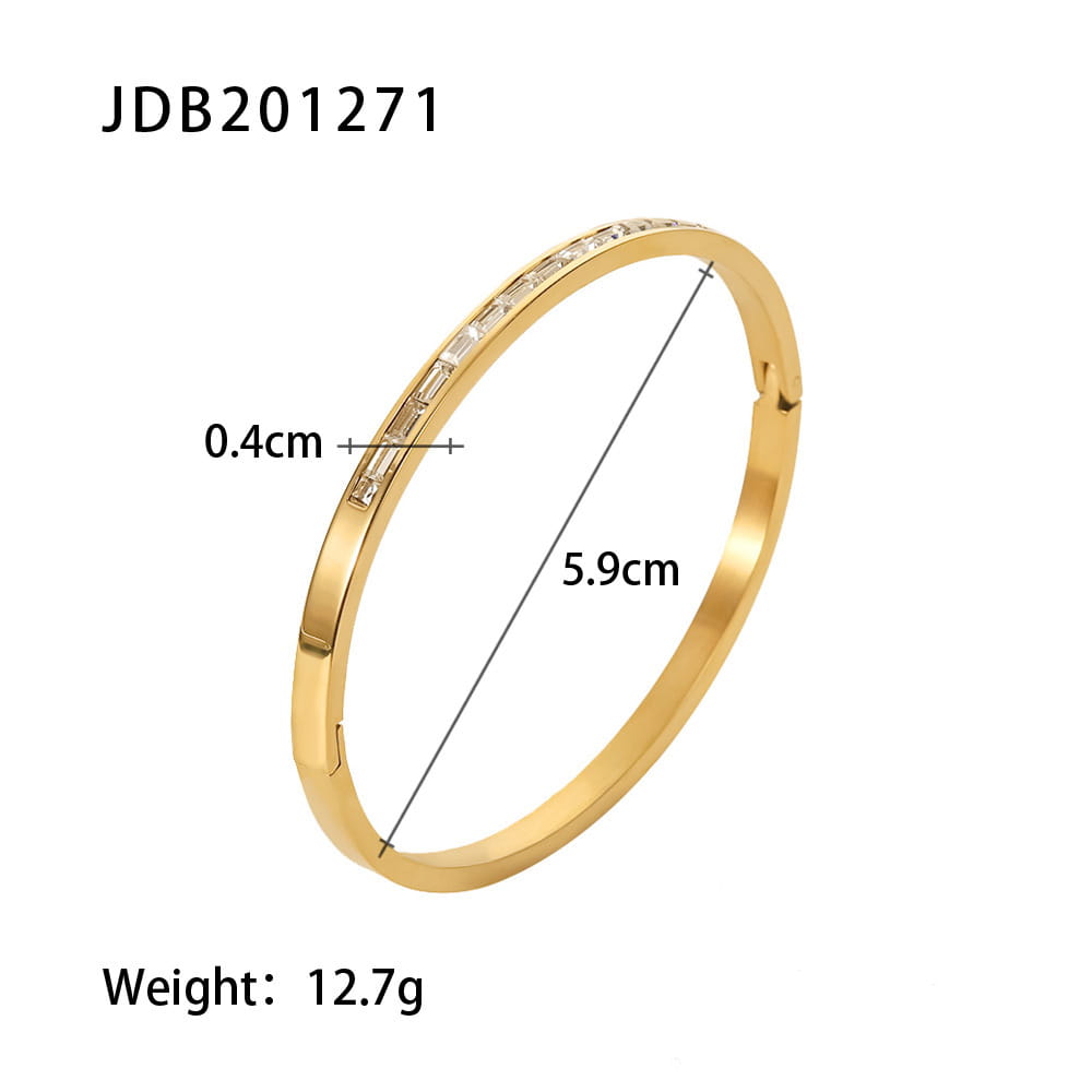Gold plated stainless steel bangle bracelet with a gold-toned smooth band and a row of rectangular-cut clear zirconia gemstones set along its inner edge.