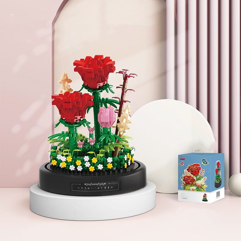 Ramillete de piezas de construcción florales en cúpula de vidrio que presenta un set de estilo lego tematizado con una rosa roja, con tallos verdes, hojas y flores de colores dispuestas sobre una base circular negra.