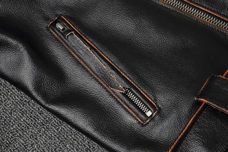Men’s cowhide leather motorcycle biker jacket in black featuring a zipper pocket with brown stitching and a metallic pull tab.