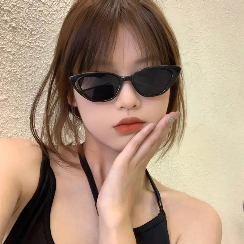 Schwarze Cat-Eye-Sonnenbrille mit dunkel getönten Gläsern, die Retro-Chic-Design und stilvollen Sonnenschutz vereint.