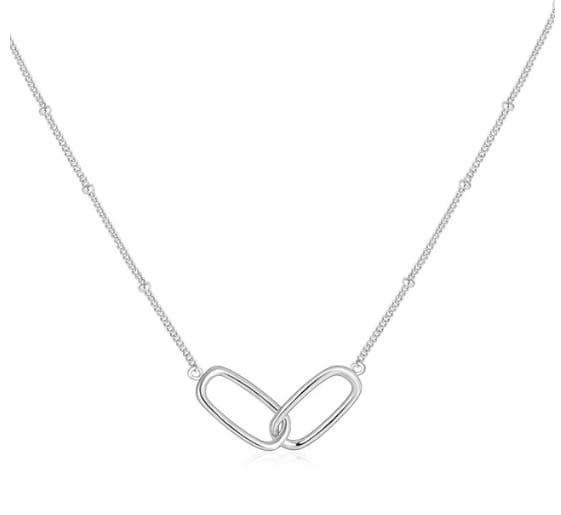 Sterling silver necklace with an interlocking oval pendant design and a green heart-shaped gemstone.