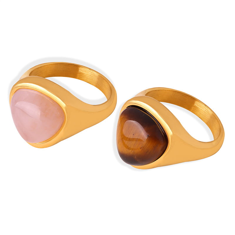 Gold-toned titanium steel heart shaped natural stone signet rings featuring a smooth rounded bezel with pink rose quartz and golden-brown tiger eye stones.