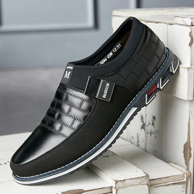 Men’s casual black leather slip-on shoe with a quilted design and silver-tone buckle detail in large sizes.