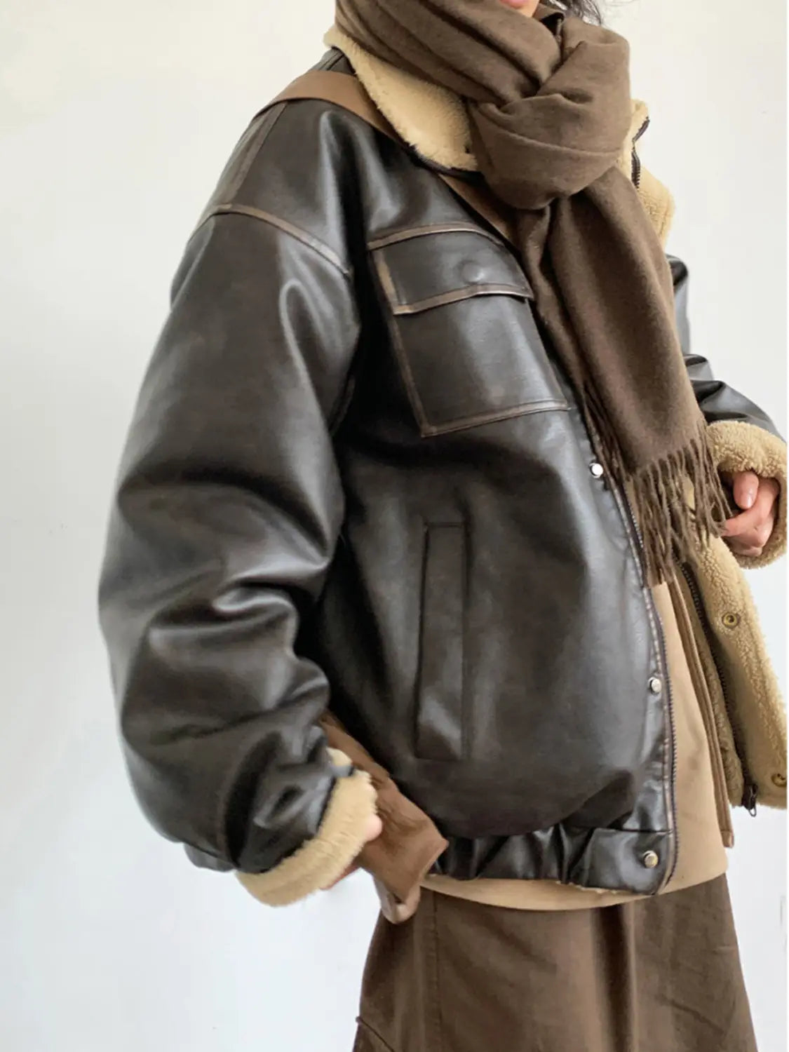 Maillard leather bomber jacket in dark brown leather with tan shearling lining and front flap pockets.