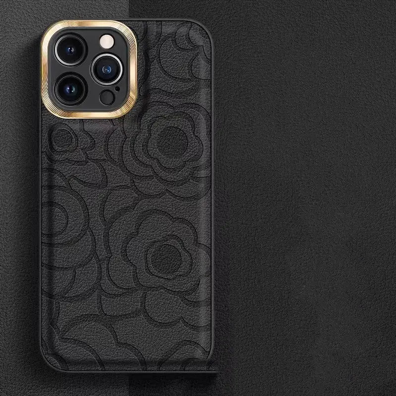 black leather camellia phone case with embossed floral pattern and gold-tone camera cutout shown from the back for iphone 11 to 14 models