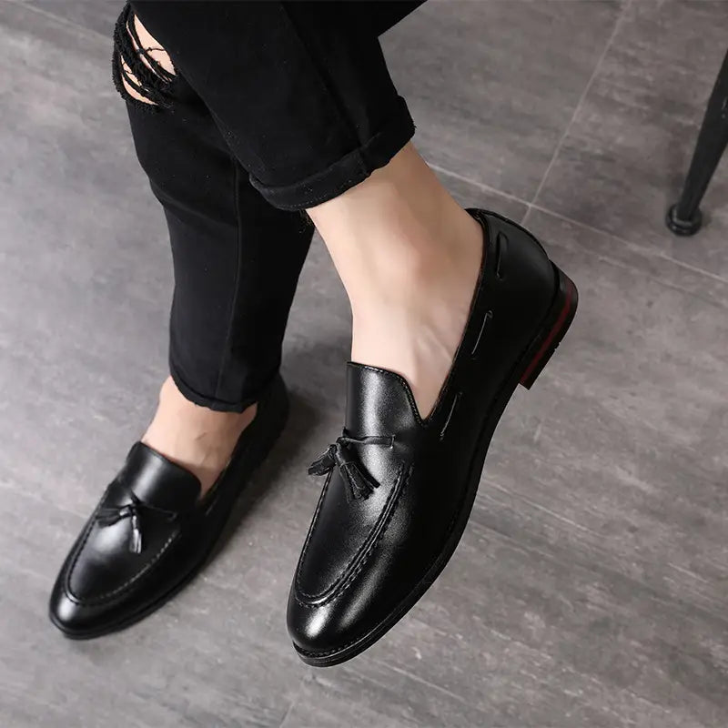 Mocassins à glands en cuir noir pour hommes, finition polie et détails de coutures subtils.