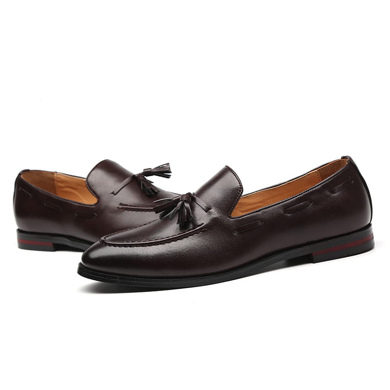 Mocassins à glands en cuir brun pour hommes, finition polie et semelles rouges contrastantes.