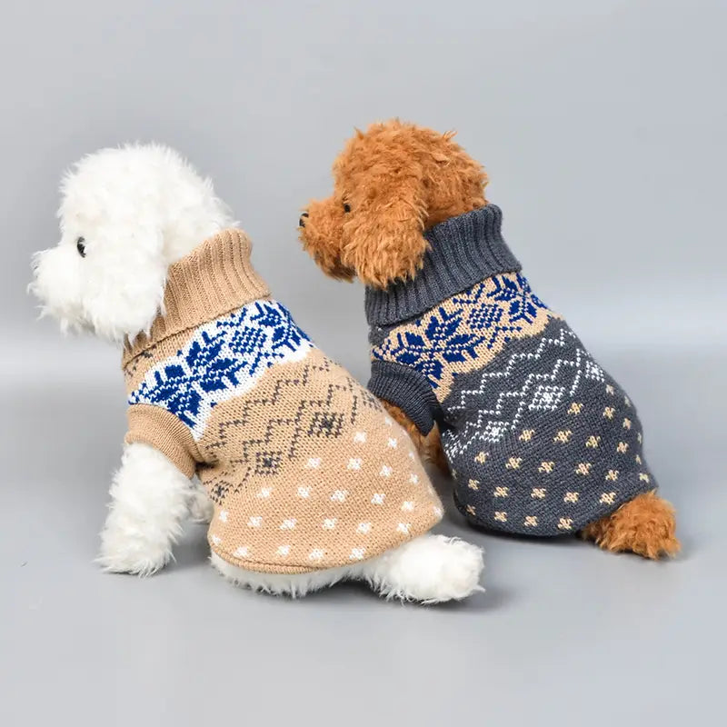 Two fluffy dogs wearing cozy knitted dog sweater knit beige snowflake winter pet apparel with festive nordic-inspired patterns in beige and blue tones.