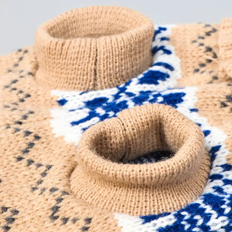 Beige knitted dog sweater with a high collar and blue and white geometric snowflake pattern for winter pet apparel.
