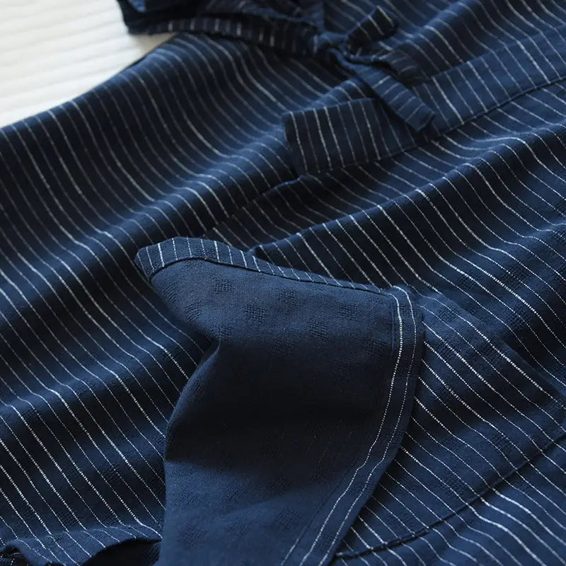 Striped cotton kimono pajama set for men featuring a dark blue linen shirt with fine white vertical stripes and a subtle woven pattern on the inner lining.