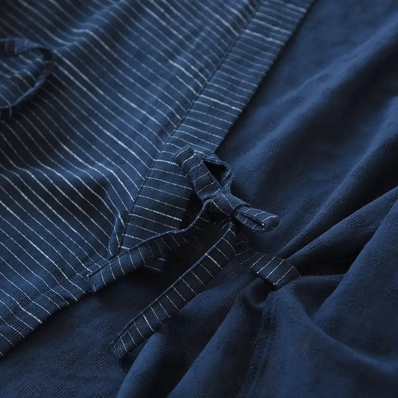 Dark blue linen kimono pajama set for men with subtle white vertical stripes and a tied fabric closure.
