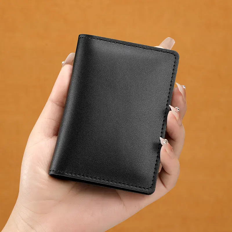 Black leather ultra thin genuine leather cowhide card holder wallet with neat stitching along the edges.