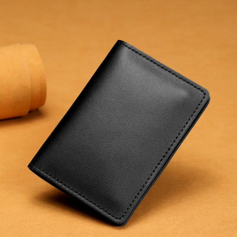 Black leather ultra thin genuine leather cowhide card holder wallet with neat stitching along the edges.