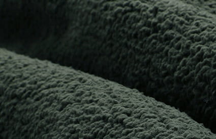 Tela de forro polar tipo plush de textura aterciopelada, forrada con polar, de color verde oscuro, de una chaqueta de invierno para tallas grandes, que muestra su superficie suave y esponjosa