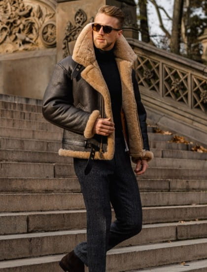 men shearling bomber jacket in black leather with tan shearling lining and cuffs displayed from the front