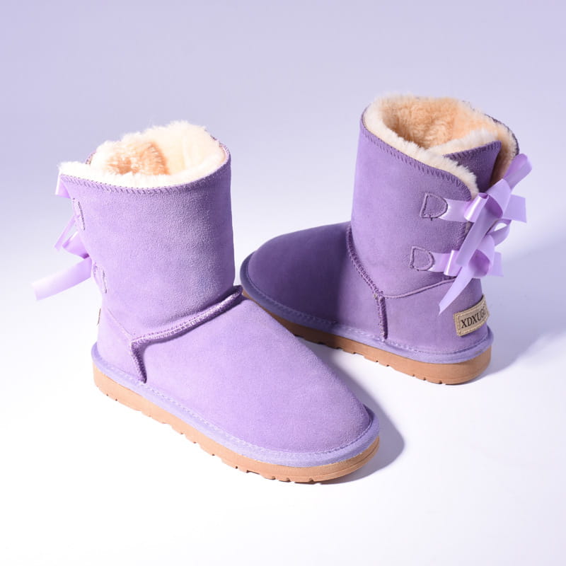 purple suede women snow boots with fluffy beige fur lining and matching ribbon bows on the back shown from the back side