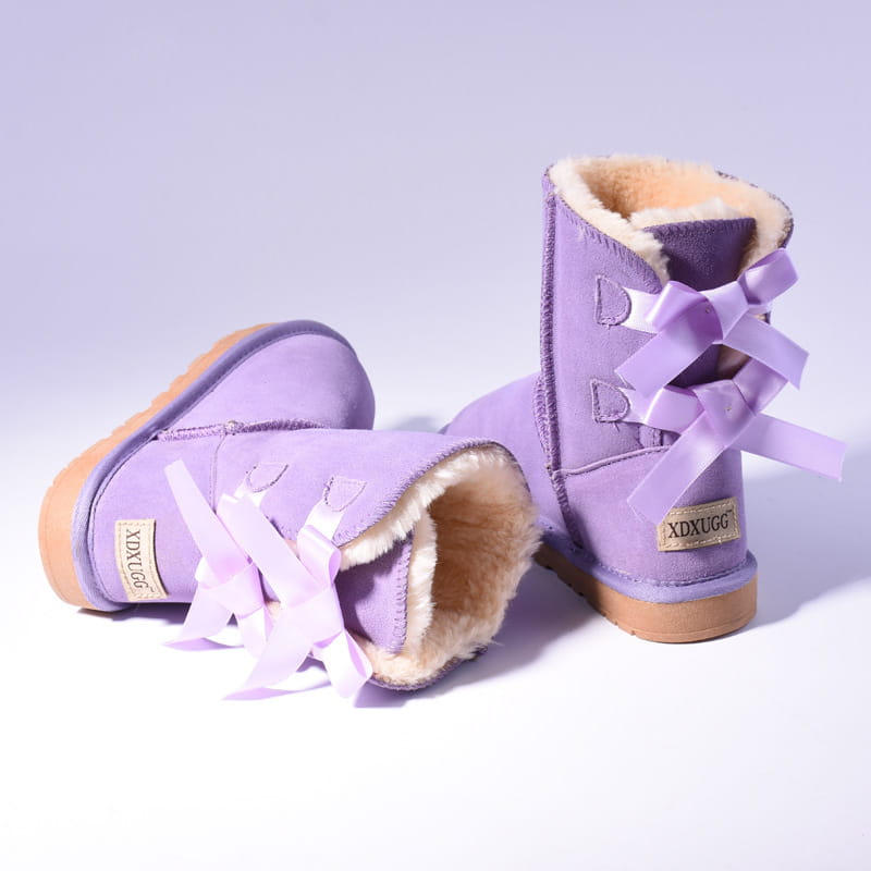 Purple women snow boots made of warm suede with plush fur lining and decorative bows on the sides suitable for winter wear.