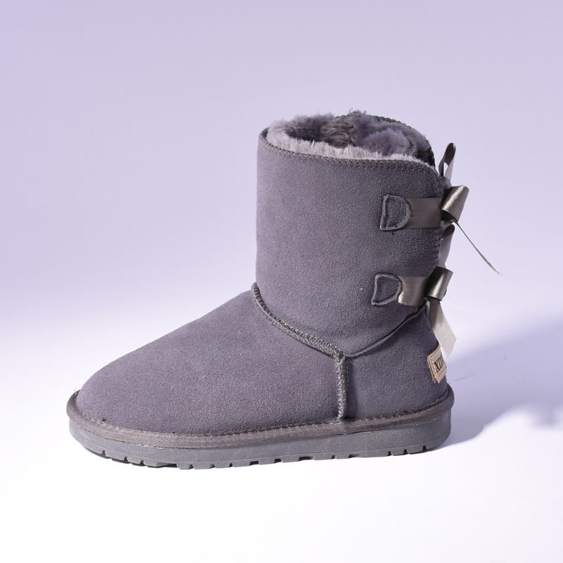 Gray suede ugg boot with plush gray lining and metallic d-shaped buckles designed as women’s snow boots for warm winter ankle wear.