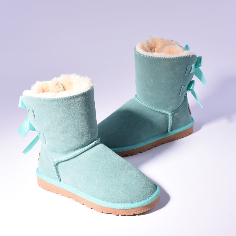 Women snow boots warm suede fur bow winter ankle boots in mint green with fluffy white shearling lining and matching ribbon bows on the sides.