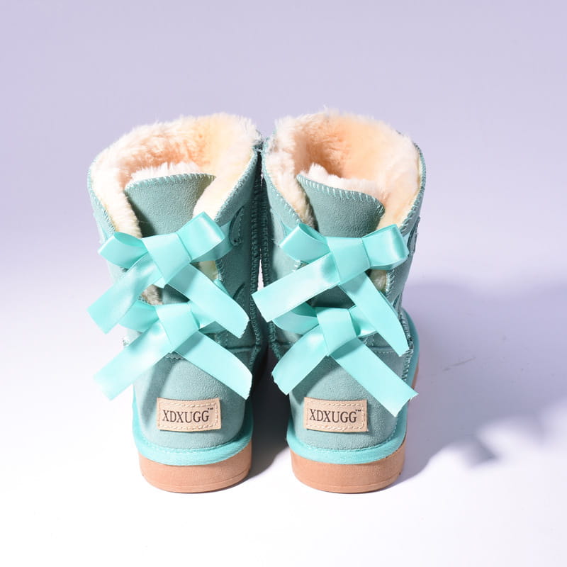 a pair of women snow boots made of mint green suede with warm beige fur lining and matching bows on the back side designed for winter use