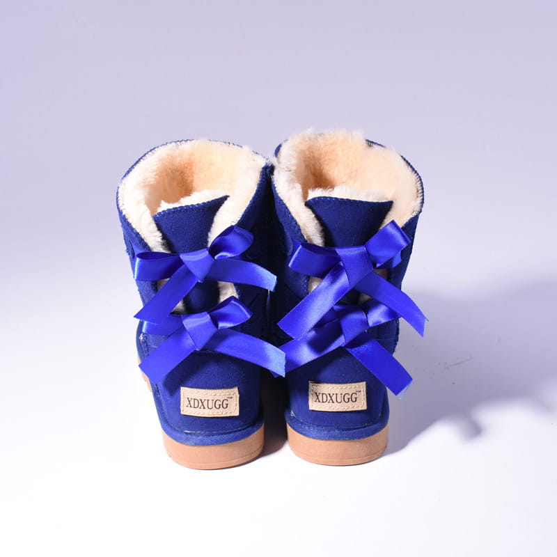 Women snow boots in royal blue suede with plush beige fur lining and satin ribbon ties for winter warmth and style.