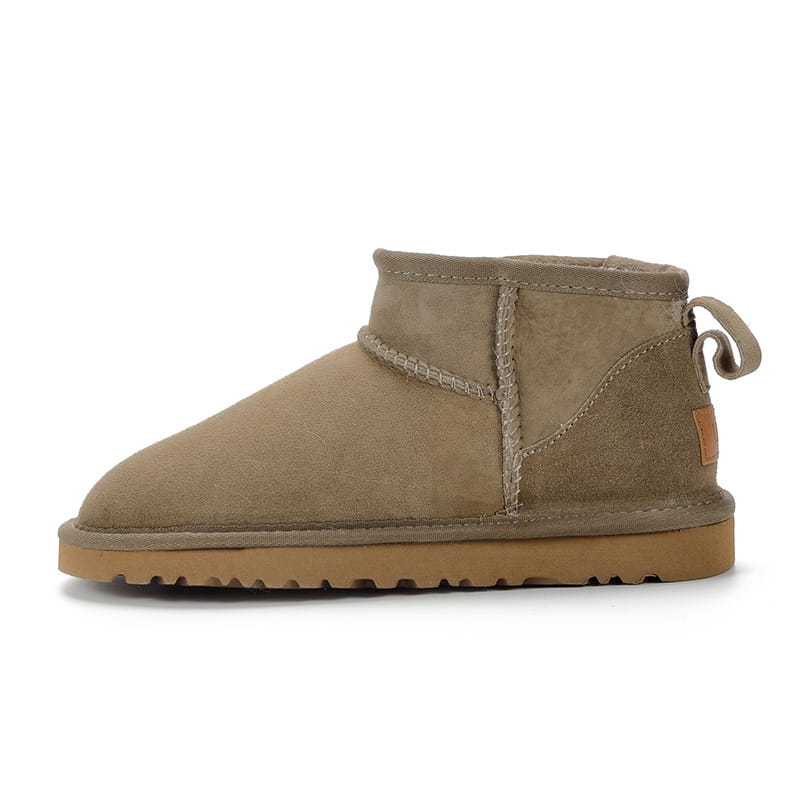 tan suede sheepskin mini snow boot with stitched seam and pull tab made of leather short shoes shown from the back side