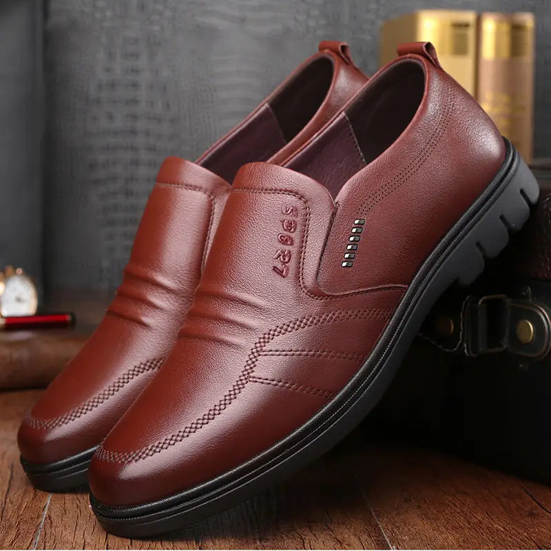 Chaussures mocassin sans lacet en cuir marron pour homme, avec semelles noires en caoutchouc antidérapantes et surpiqûres décoratives.