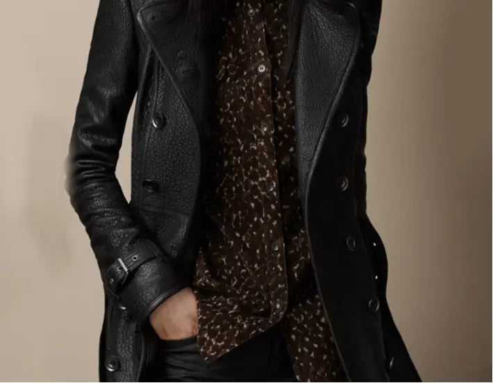Black textured faux leather double breasted trench coat with belted cuffs and buttons shown from the back.