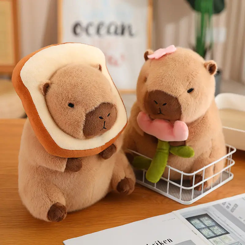 Soft tan plush capybara toy featuring a bread-shaped headpiece and a pink bow accessory from the capybara plush toy with bread and flower outfits collection.