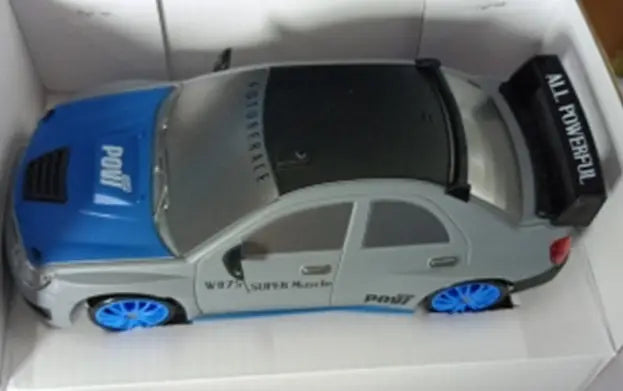 Voiture de drift RC grise et bleue à propulsion 4 roues motrices à haute vitesse, télécommandée, avec un toit noir, un aileron et des roues bleues vibrantes.