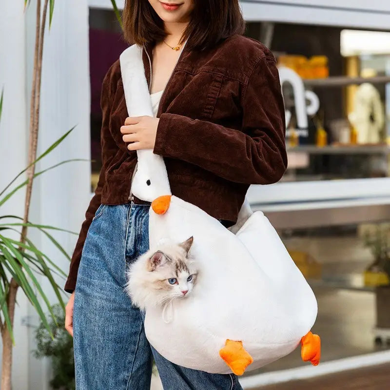 White plush goose-shaped pet carrier bag backpack with orange beak and feet featuring a soft fabric body designed to comfortably hold small animals.