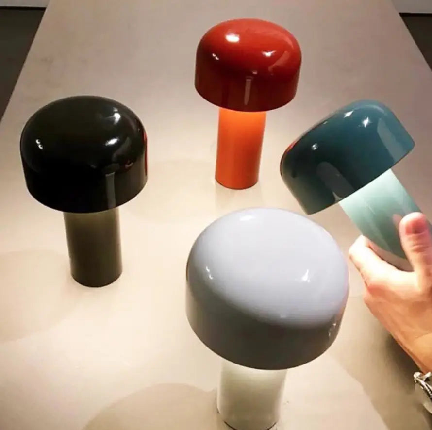 A sleek glossy mushroom table lamp with a vibrant red cap and orange stem featuring cordless touch rechargeable LED lighting.