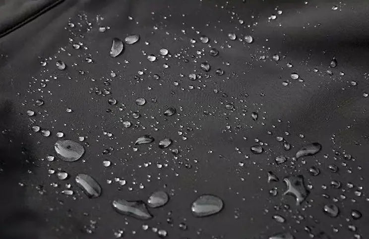 schwarzer wasserabweisender Stoff mit verstreuten Kondensationsstropfen, dargestellt in einem Set aus Herren-Taktikfleecejacke und Cargohosen