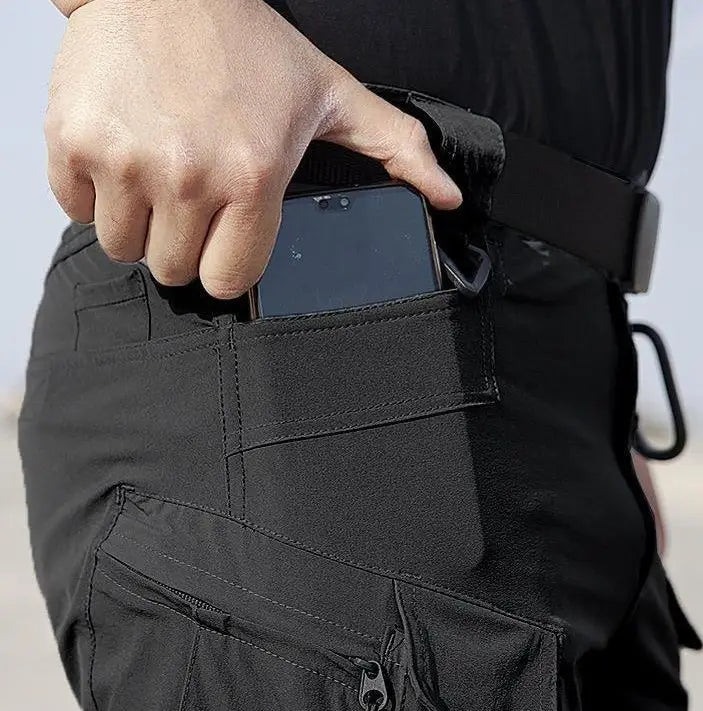 Schwarze taktische Cargohosen mit mehreren Taschen und verstärkter Naht, dargestellt im Set aus Herren-Taktikfleecejacke und Cargohosen.