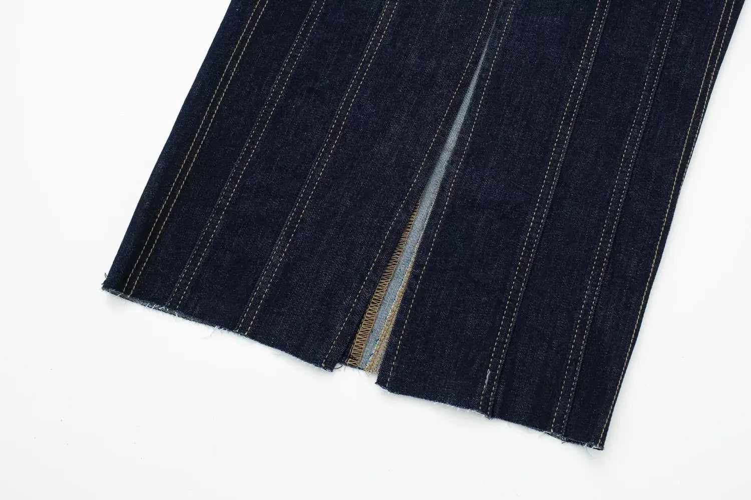 Pantalon en denim indigo foncé avec surpiqûres claires contrastantes et doublure intérieure visible, s’accordant avec la robe midi sans bretelles en denim à rayures fantaisie, dotée d’un détail de fermeture à glissière.