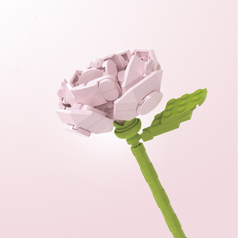 Un délicat bouquet de fleurs en briques, rose bonsaï, en rose, avec une tige verte et une feuille, réalisé à partir de briques en plastique imbriquées.