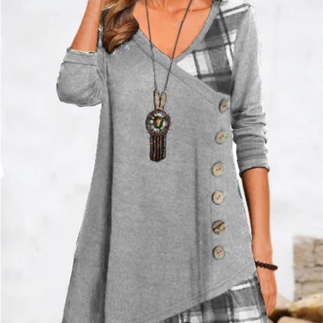 Gray long-sleeved knit tunic dress with a v-neck, asymmetrical plaid patchwork on the shoulder and side, and wooden buttons down the front.