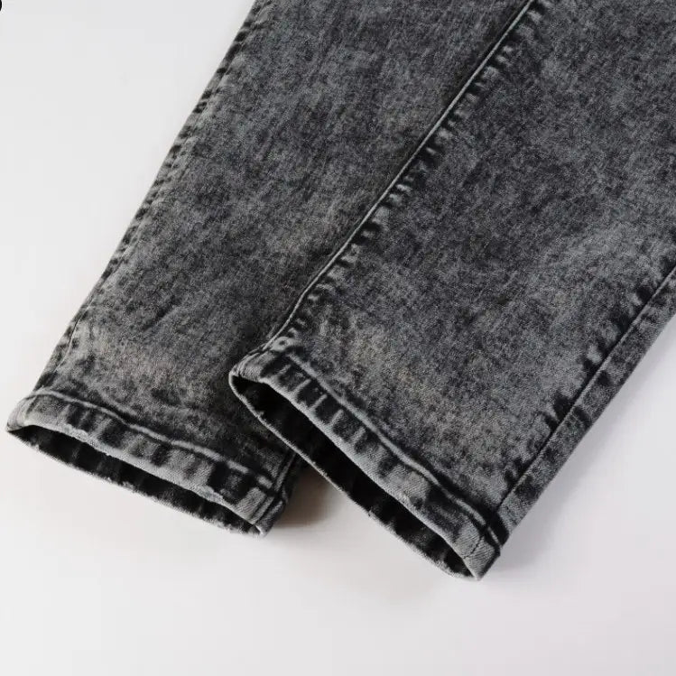 Men’s smoky gray slim fit distressed retro skinny jeans made of dark gray denim with a faded texture and visible stitching along the seams.