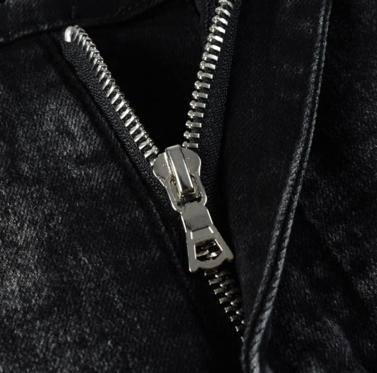 silver-toned metal zipper with sturdy pull tab on men’s smoky gray slim fit distressed retro skinny jeans made of dark textured fabric
