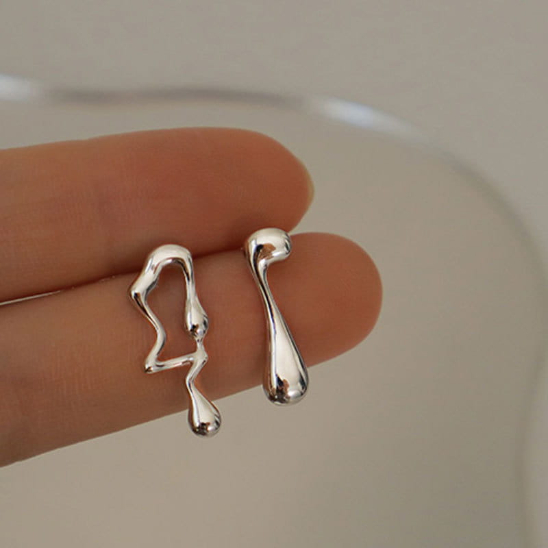 Asymmetrische Ohrstecker aus flüssigem Silberlava weisen eine abstrakte, glatte, flüssigkeitsartige Gestaltung in Silber auf.