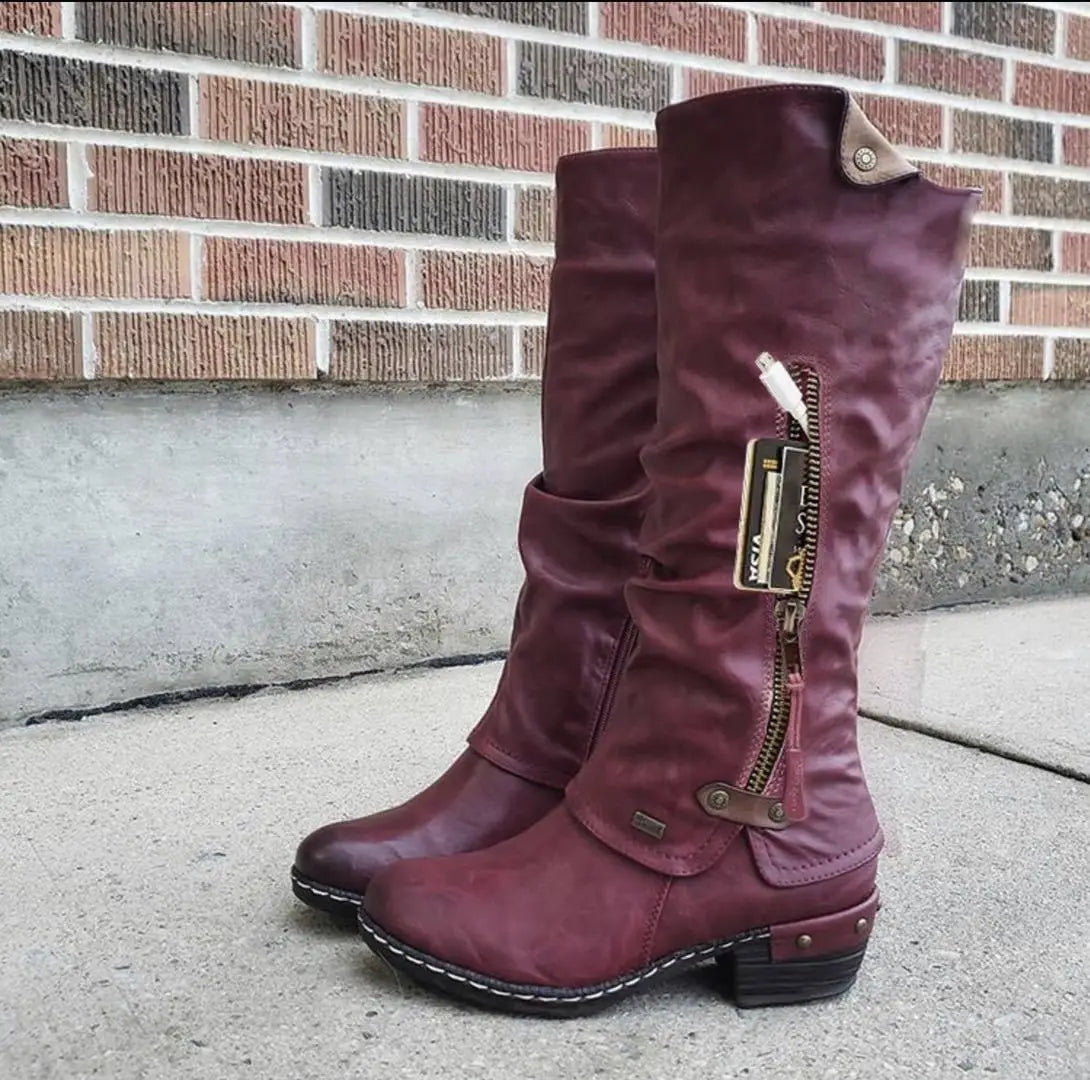 Knee high maroon suede leather boots with block heel featuring a side zipper and decorative metal accents.