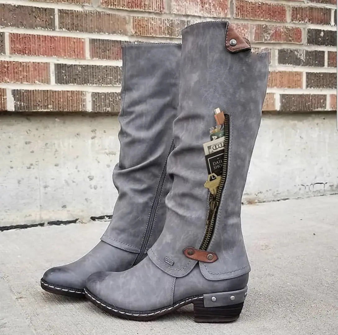 Knee high suede leather boots featuring gray suede with brown leather accents and a side zipper with block heel.