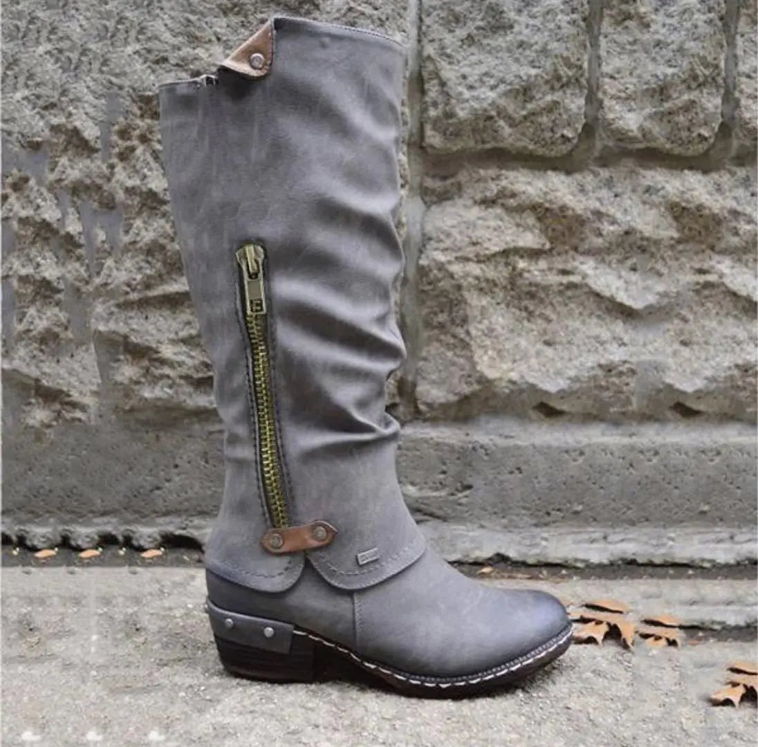 Gray suede knee high leather boot with block heel featuring a green zipper and brown leather accents.