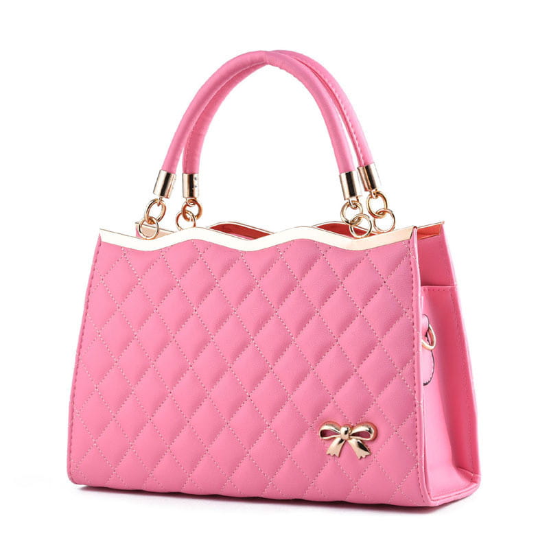 Pink quilted crossbody handbag with gold-tone bow and handles featuring gold hardware.