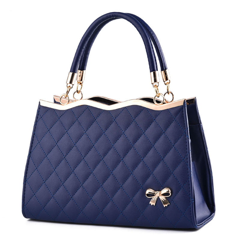 Navy blue quilted crossbody handbag featuring a gold-tone bow and gold hardware.