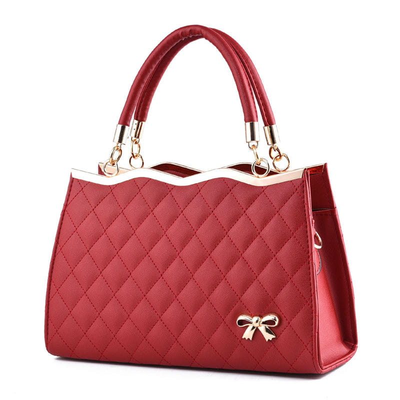 Red quilted crossbody handbag with gold-tone bow and handles featuring gold hardware.