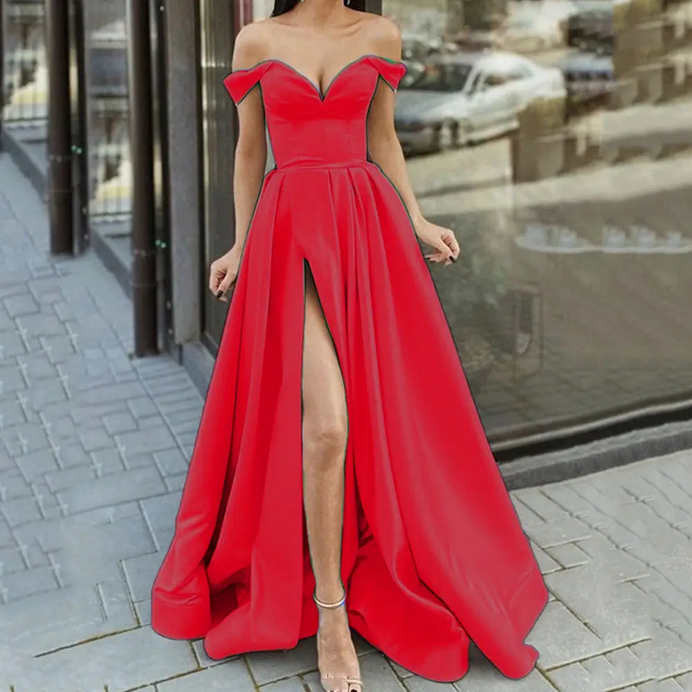 A vibrant red satin elegant off shoulder v neck maxi dress with a high slit and flowing skirt.