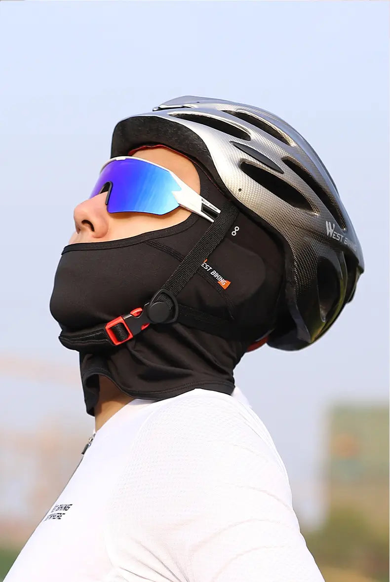 Black cycling face mask with red buckle and bike branding worn under a silver helmet designed for sun protection in neon green cycling balaclava style.