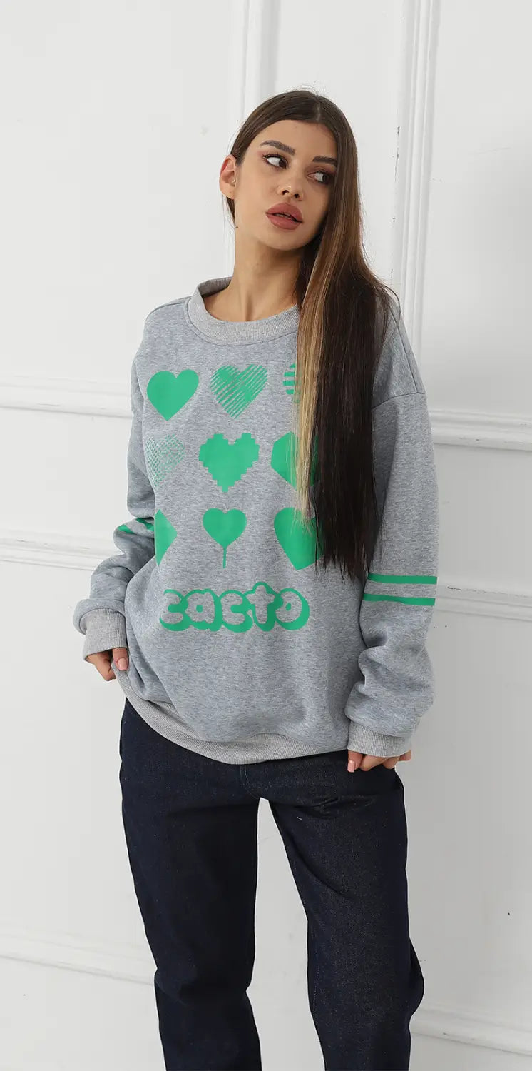 Gray oversized sweatshirt made of soft material featuring a green heart and cacto graphic print.